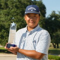 Yilang Chen with trophy in front of arch - 2026 - AJGA Junior All-Star Invitational 