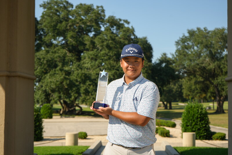 Yilang Chen with trophy in front of arch - 2026 - AJGA Junior All-Star Invitational 